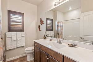 Bathroom with vanity, a shower with shower curtain, and dark wood finished floors