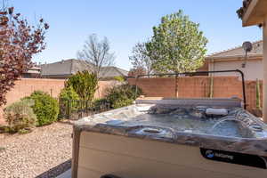 Fenced backyard featuring a hot tub