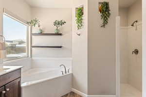 Full bathroom with a garden tub, walk in shower, and vanity