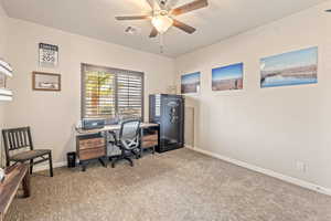 Office area with light colored carpet and a ceiling fan