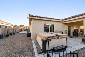 Back of property featuring a patio, a fenced backyard, stucco siding, and a tiled roof