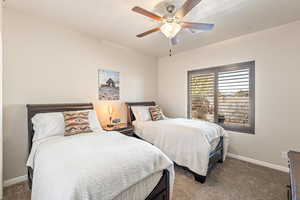 Bedroom with dark carpet and a ceiling fan