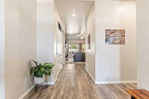 Hallway with light wood-style floors and baseboards