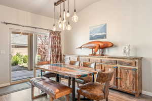 Dining area featuring light wood finished floors and vaulted ceiling