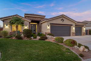 Mediterranean / spanish house featuring stone siding, stucco siding, driveway, and a garage