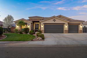 Mediterranean / spanish home with stone siding, stucco siding, an attached garage, and a tiled roof