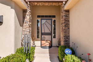 Entrance to property with stucco siding and stone siding