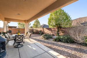 Fenced backyard featuring a patio and grilling area