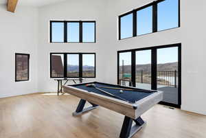 Playroom featuring a mountain view, billiards, light wood finished floors, and a high ceiling
