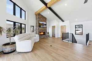 Living room featuring a fireplace, light wood-style flooring, and vaulted ceiling