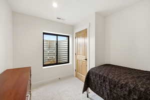 Bedroom featuring light carpet and baseboards