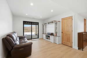 Living area featuring light wood finished floors and recessed lighting