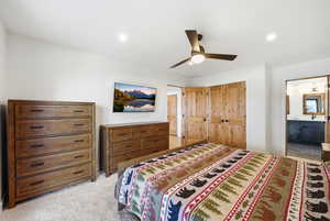 Bedroom featuring light carpet, a closet, connected bathroom, a ceiling fan, and recessed lighting
