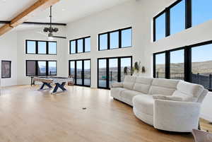 Living room with light wood finished floors, a mountain view, and hanging lights