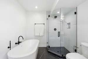 Full bath featuring a marble finish shower, a freestanding bath, and recessed lighting
