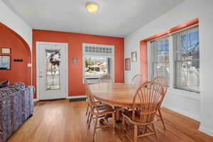 Dining area with light wood-style flooring and arched walkways