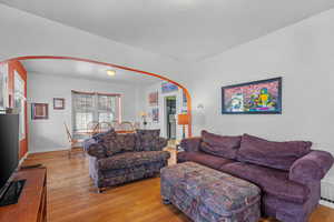 Living area featuring light wood-style flooring and arched walkways