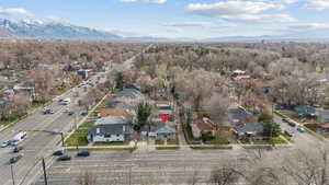 Aerial perspective of suburban area featuring a mountainous background and a forest