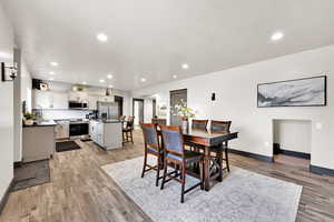 Dining room with recessed lighting, light wood finished floors, and a textured ceiling