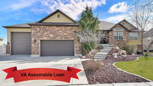 View of front facade featuring stone siding, concrete driveway, an attached garage, and stucco siding