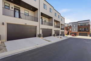 View of building exterior with concrete driveway and a garage