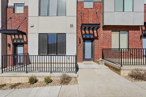 View of front entry with brick siding and stucco siding