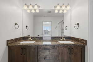 Primary Bathroom featuring double vanity and a stall shower