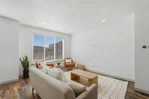 Family room with dark wood-style flooring, a textured ceiling, and recessed lighting