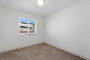 Bedroom with light colored carpet and baseboards