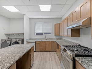 Kitchen featuring wood-finish cabinetry, granite-style countertops, and stainless steel appliances