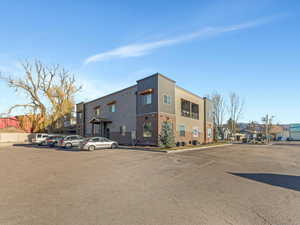 View of building exterior featuring uncovered parking