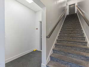 Carpeted staircase with metal handrails