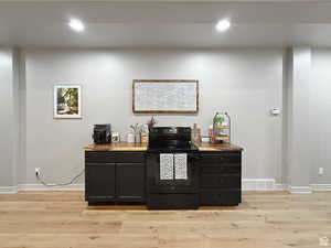 Basement kitchen with light wood-style flooring and recessed lighting