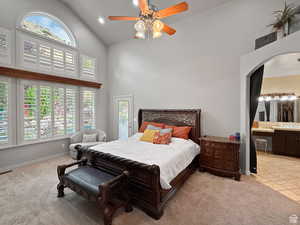 Primary Bedroom on main floor featuring lofted ceiling, light carpet, recessed lighting, ceiling fan, and access to exterior