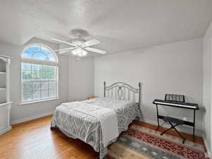 Second floor bedroom with light wood finished floors, a ceiling fan.