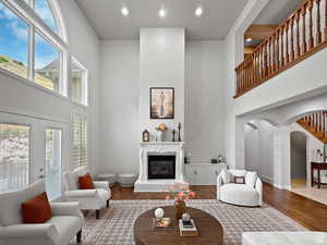 Great room featuring arched walkways, wood finished floors, plenty of natural light, a high ceiling, and recessed lighting