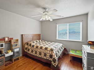 Second floor Bedroom with dark wood finished floors, ceiling fan, and a textured ceiling