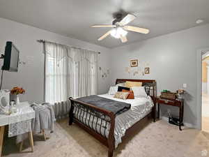 Main floor Guest Bedroom featuring light colored carpet and ceiling fan