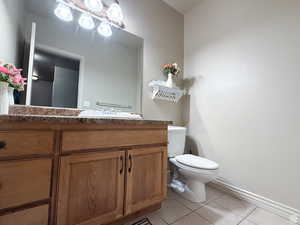 Basement Half bath with vanity and light tile patterned floors