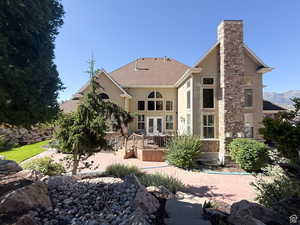 Back of property featuring french doors, stucco siding, a wooden deck, and roof with shingles