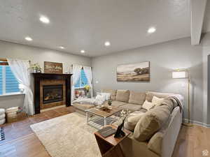 Basement Living room featuring a fireplace, light wood-style floors, and recessed lighting