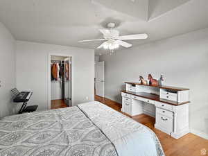Second floor Bedroom with a walk-in closet, dark wood finished floors, and ceiling fan