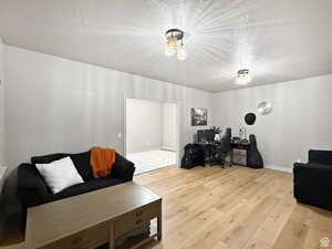 Basement Home office featuring light wood-style floors and a textured ceiling