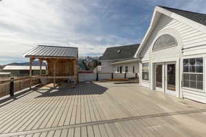 Wooden deck with a mountain view and french doors. Outdoor Pergola started for hot tub or outdoor kitchen.
