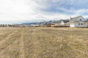 View of yard with a deck with mountain view and a view of rural / pastoral area
