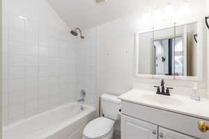 Bathroom featuring vanity, lofted ceiling, and bathtub / shower combination