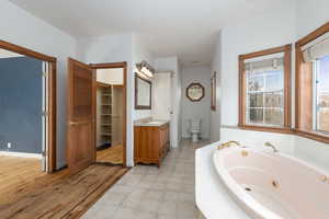 Primary Full bath featuring vanity, a jetted tub, and two spacious closet.