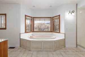Primary Bathroom with a bath and vanity