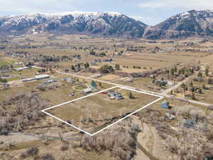 Aerial overview of property's location with property parcel outlined, a mountainous background, and rural landscape