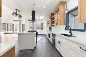 Kitchen featuring open shelves, extractor fan, light stone countertops, recessed lighting, and glass insert cabinets
